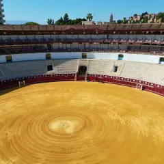 La plaza de toros de Málaga, con su arena dorada y gradas vacías, espera la próxima corrida.