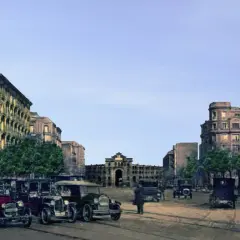 Vista de la antigua plaza de toros de Madrid, con edificios históricos y coches de época.