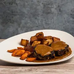 Plato de rabo de toro con patatas rústicas y zanahorias glaseadas. Una deliciosa receta para disfrutar.