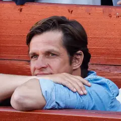 Hombre con camisa vaquera azul, apoyado en sus brazos, con expresión pensativa. Se intuye el paso del tiempo en el rostro de El Juli, edad que refleja su experiencia.