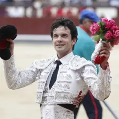 Juan del Álamo, torero, sonríe con un ramo de rosas en la mano y su montera en la otra, tras una faena.
