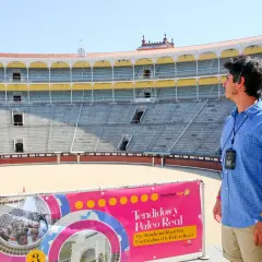 Un guía turístico en la plaza de toros de Madrid, con los tendidos y el Palco Real al fondo.