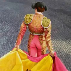 Torero con traje de luces rosa y dorado, sujetando un capote amarillo y rosa. Aprende como hacer un capote de torero.