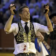 Manuel Escribano, triunfador, levanta las orejas del toro en la plaza.