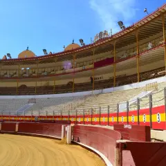 La grada de la plaza de toros, vacía y bajo un cielo azul, espera la emoción.