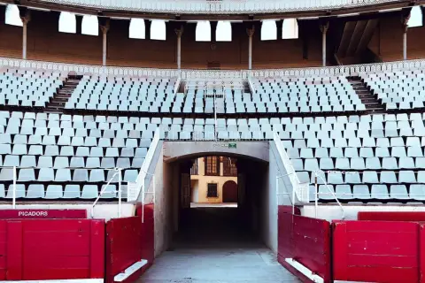 Tendidos vacíos en la plaza de toros de Las Ventas, con el plano de asientos visible y barreras rojas de picadores.