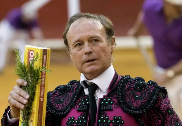José Vázquez, torero con traje de luces, sostiene un ramo de romero y una caja amarilla.