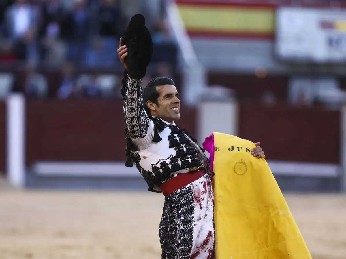 Un torero sonriente levanta su montera, con la muleta amarilla en la mano. Las caras de toreros son un reflejo de pasión y valentía.